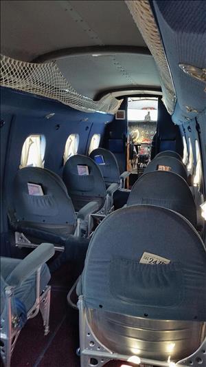 A row of old airplane seats leading to the cockpit door